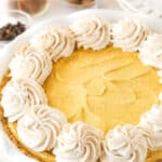 A Pumpkin Ice Cream Pie decorated with swirls of whipped cream.