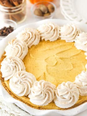 A Pumpkin Ice Cream Pie decorated with swirls of whipped cream.