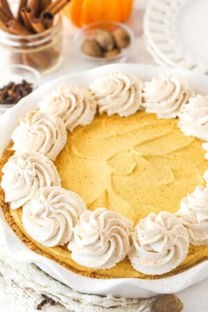 A Pumpkin Ice Cream Pie decorated with swirls of whipped cream.