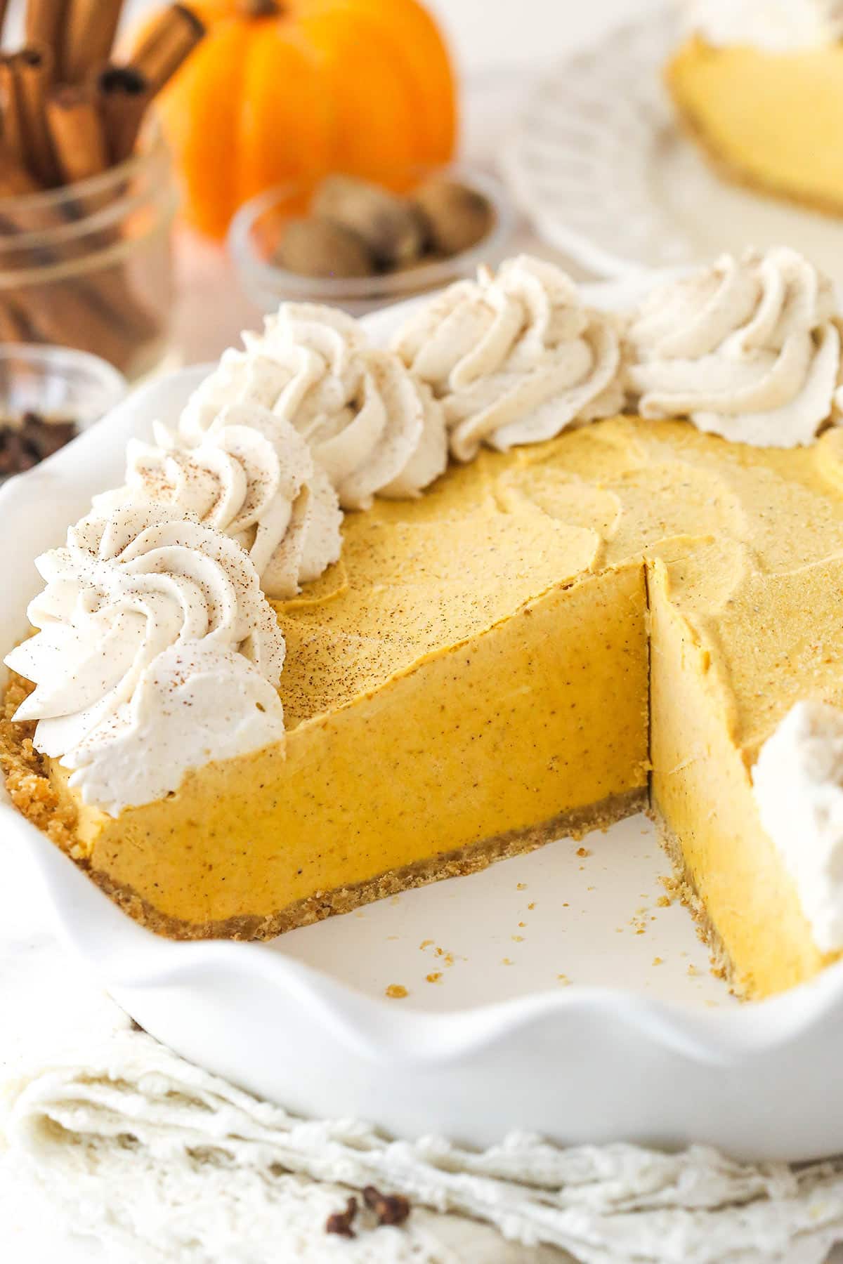 A Pumpkin Ice Cream Pie in a white pie plate with a slice removed to show interior.