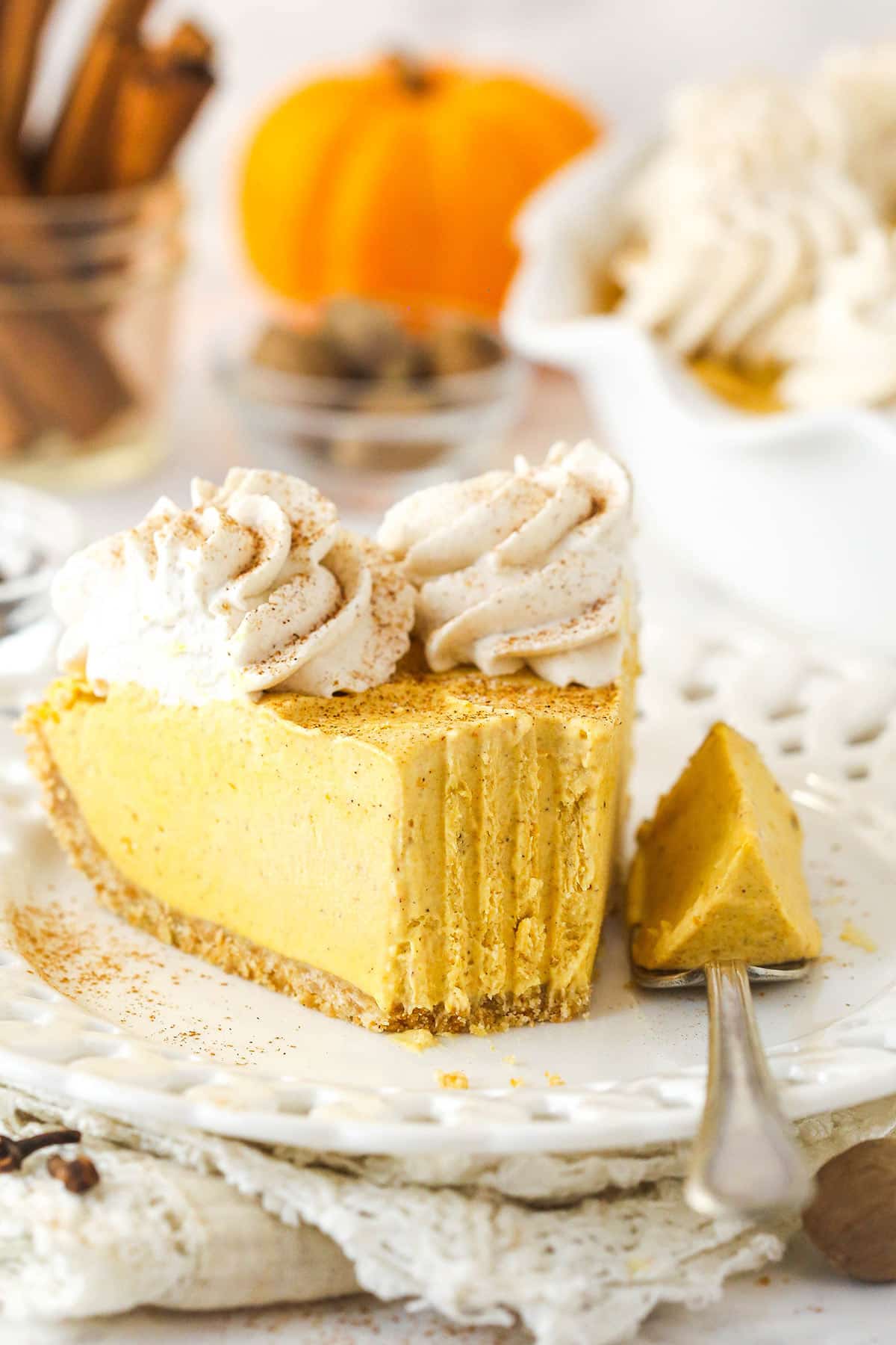 A slice of Pumpkin Ice Cream Pie on a small plate with a bite removed.