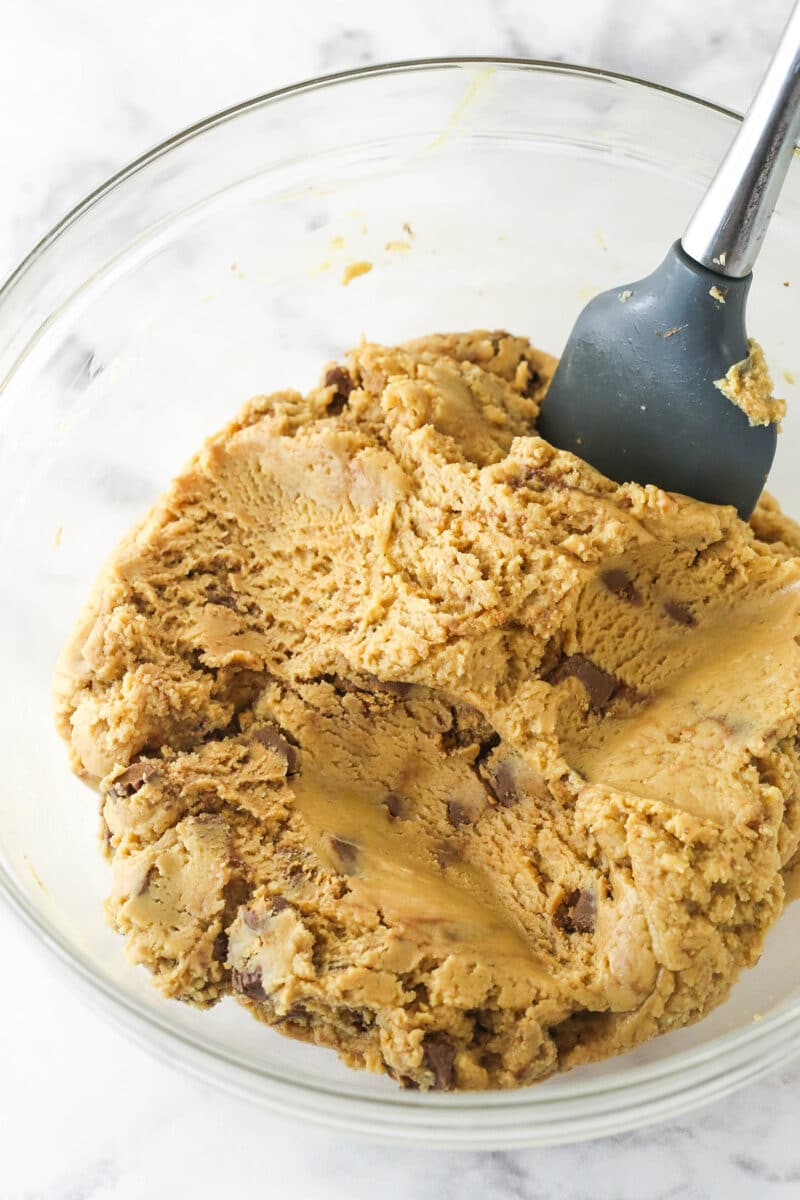 Stirring Reese's pieces into the fudge mixture