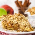 A slice of dutch apple pie on a white plate