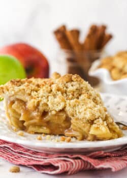 A slice of dutch apple pie on a white plate