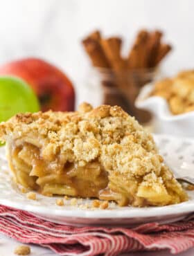 A slice of dutch apple pie on a white plate