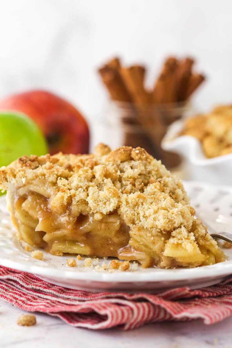 A slice of dutch apple pie on a white plate