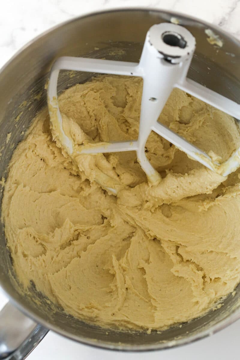 Creamed butter and sugars in a metal mixing bowl.