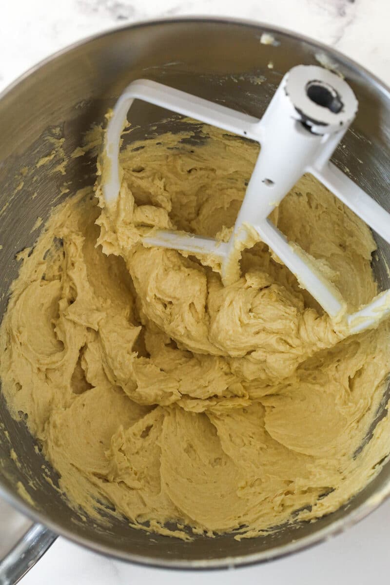 Maple cookie bar batter in a metal mixing bowl after the egg and maple extract have been added.