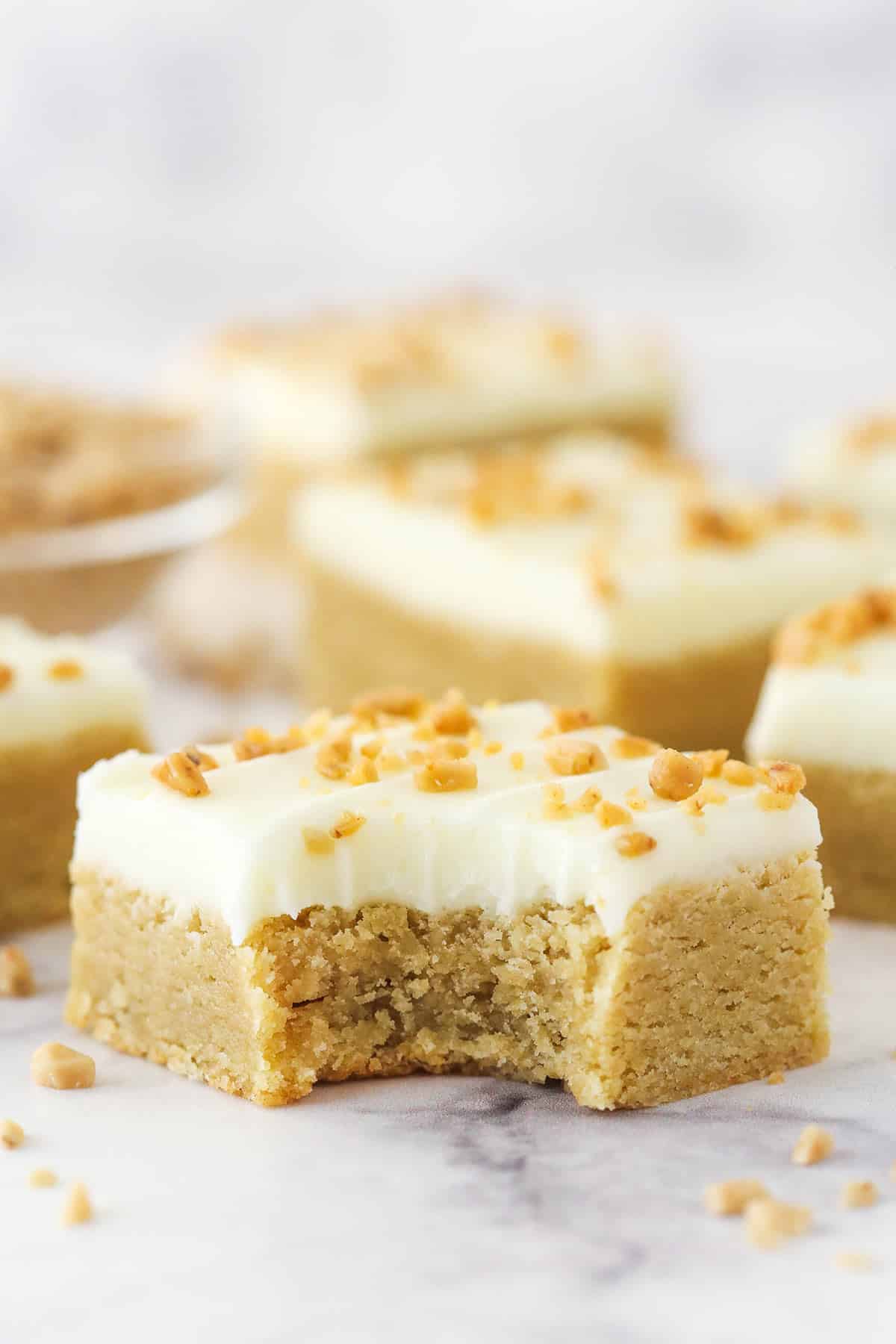 A Frosted Maple Cookie Bar with a bite taken out of it.