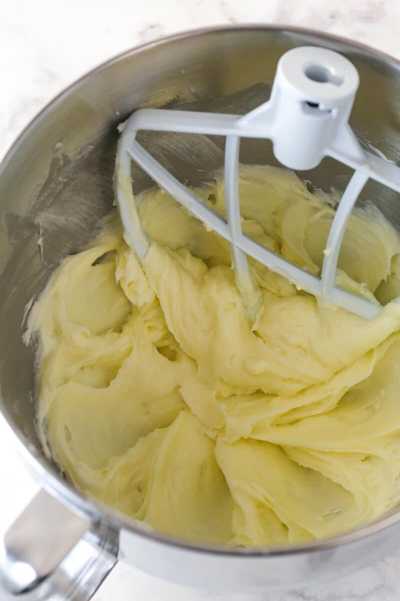 Cream cheese and sugar beaten together in a metal mixing bowl.