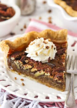 A slice of maple pecan pie topped with whipped cream