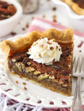 A slice of maple pecan pie topped with whipped cream