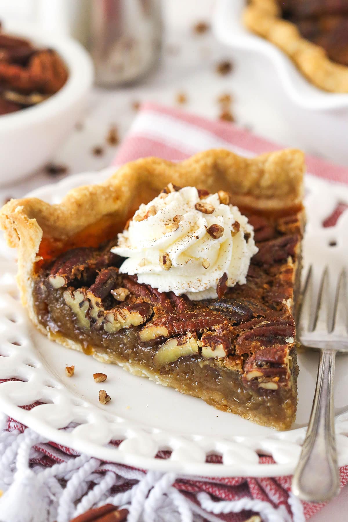 A slice of maple pecan pie topped with whipped cream