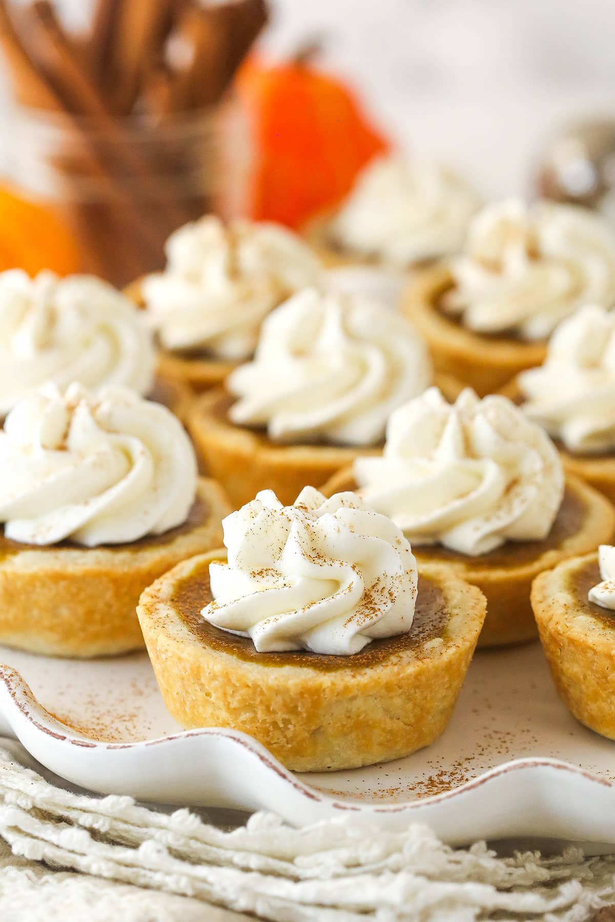 Mini pumpkin pies topped with whipped cream on a tray