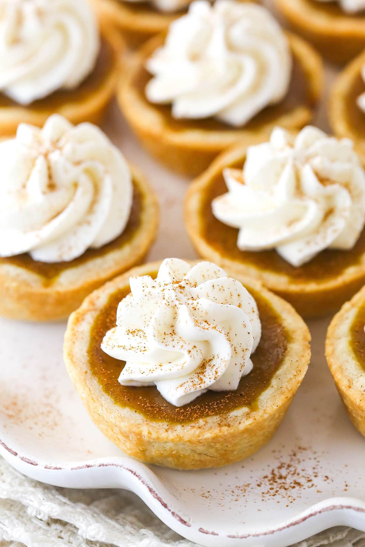 Mini pumpkin pies with whipped cream on a tray