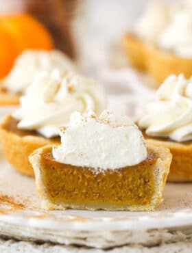 Front view of a mini pumpkin pie cut in half to see the pumpkin filling