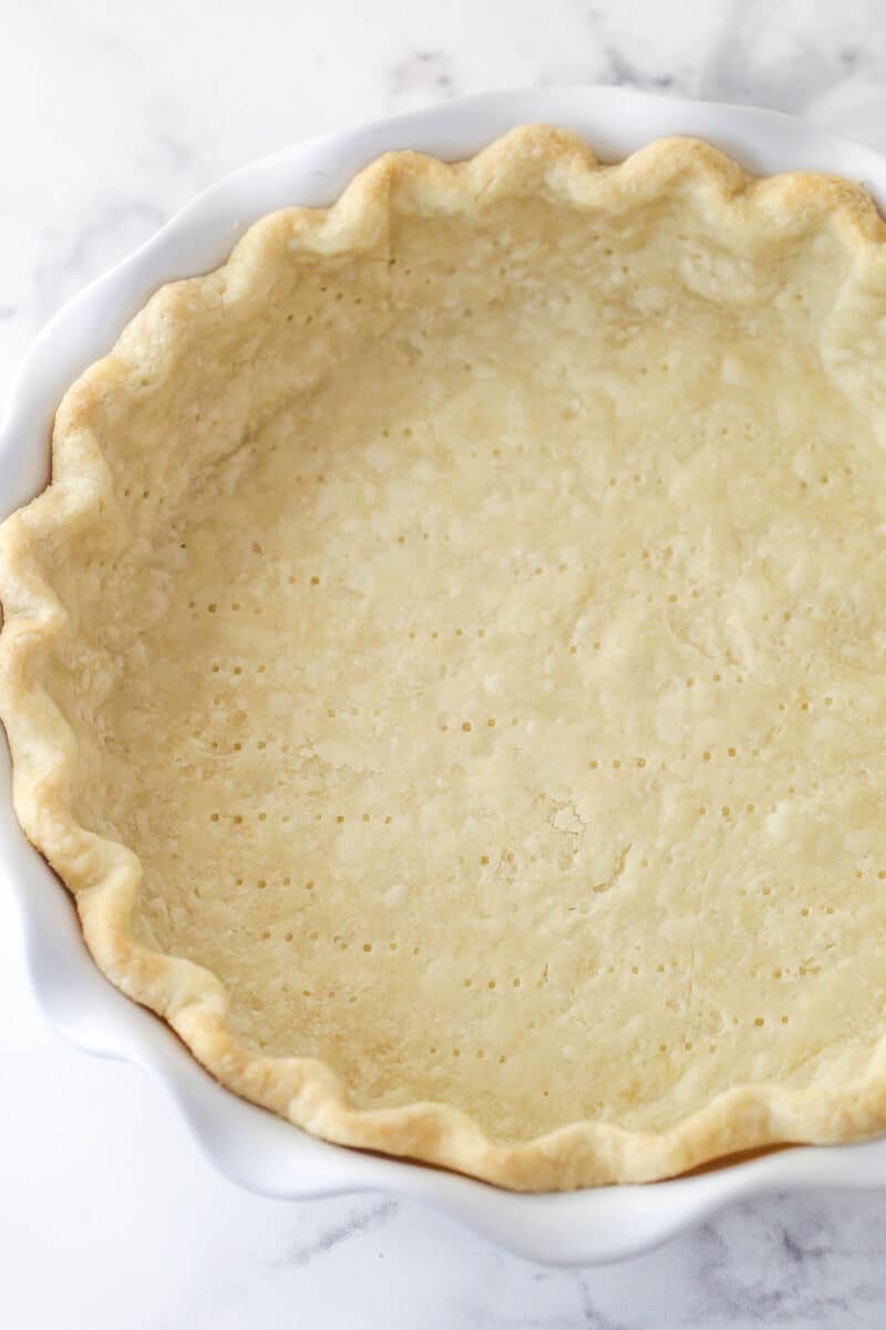 Partially baked pie crust in a pie dish