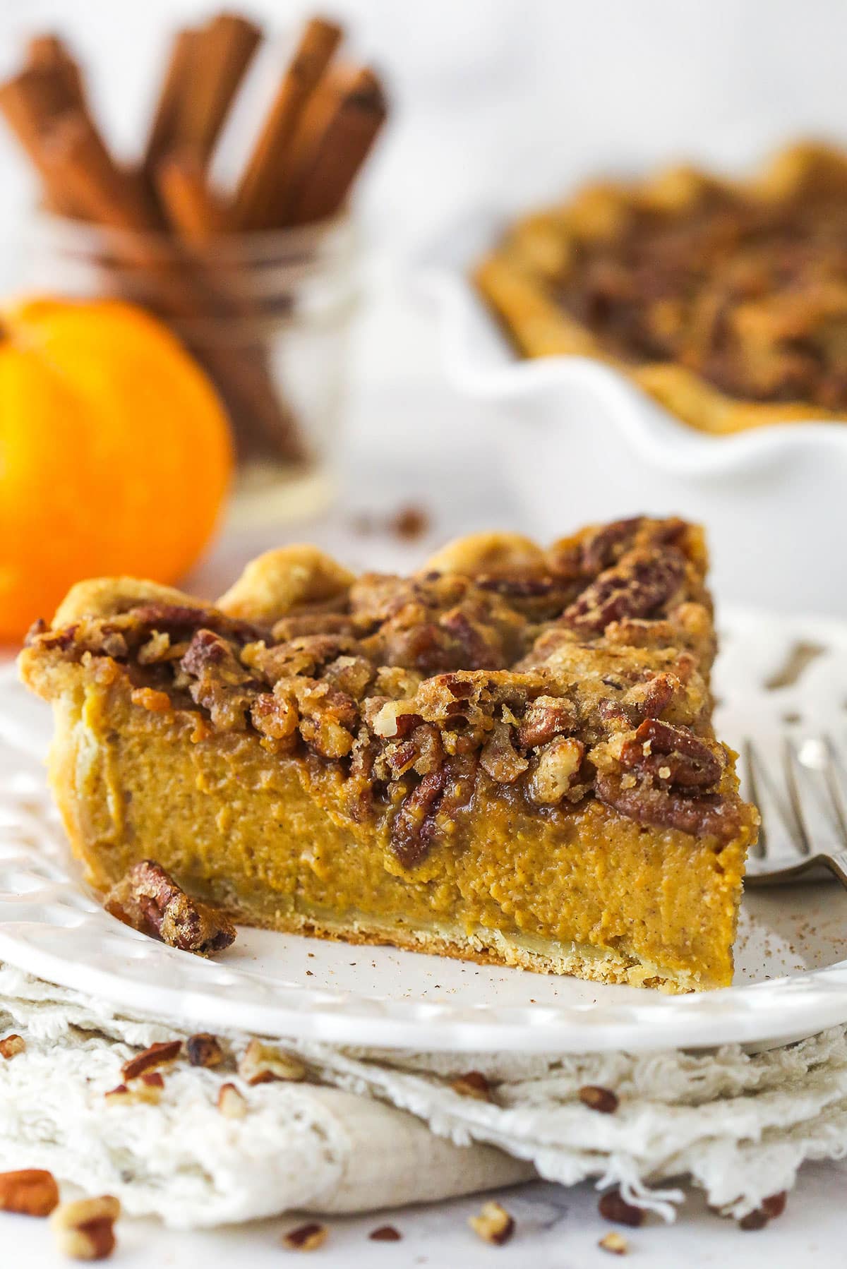 A slice of praline pumpkin pie on a white plate.