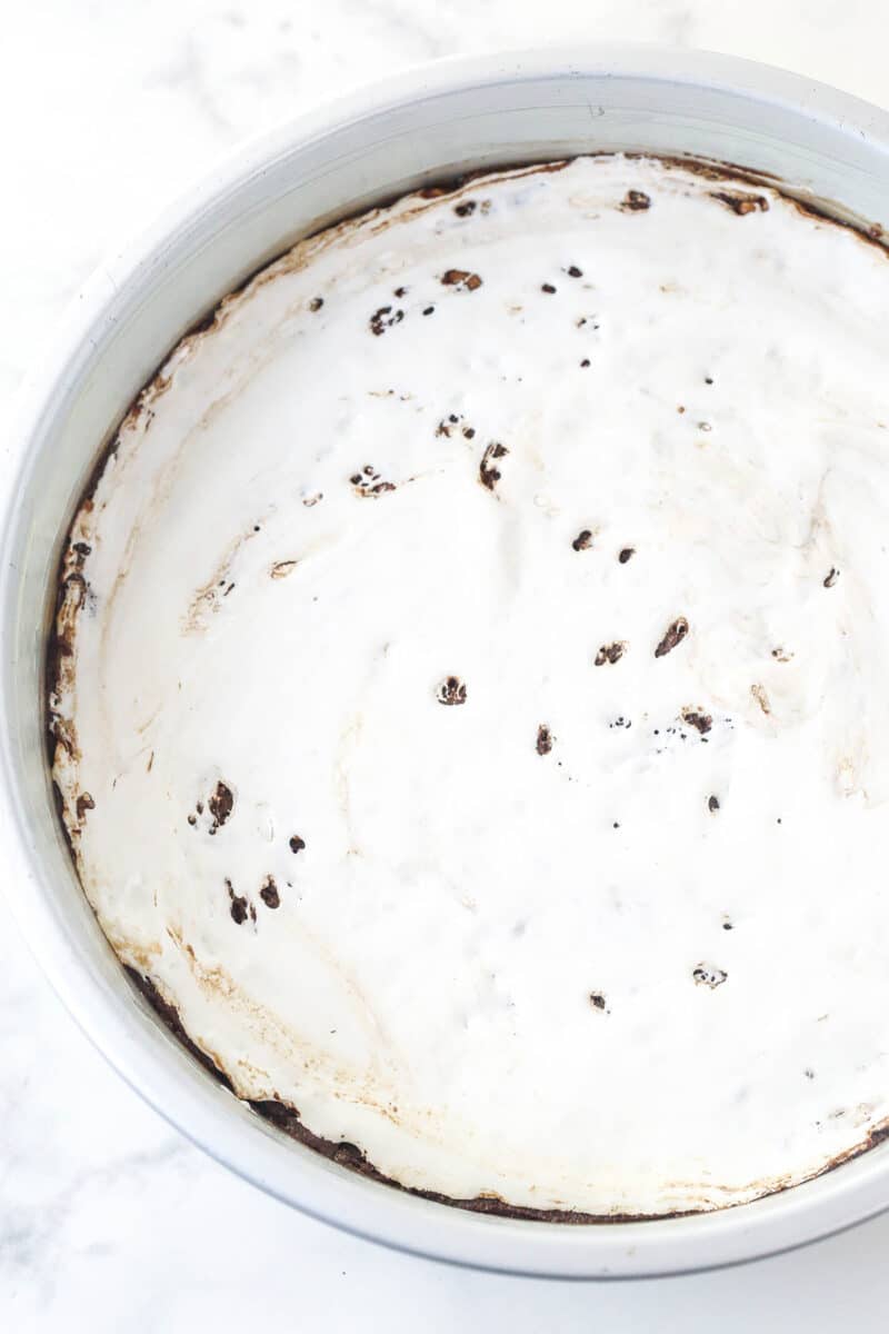 A layer of marshmallow fluff covering Rocky Road Cookie Cake dough.