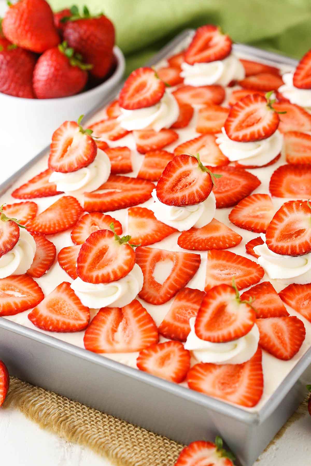 Overhead view of a full Strawberry Poke Cake in a silver pan