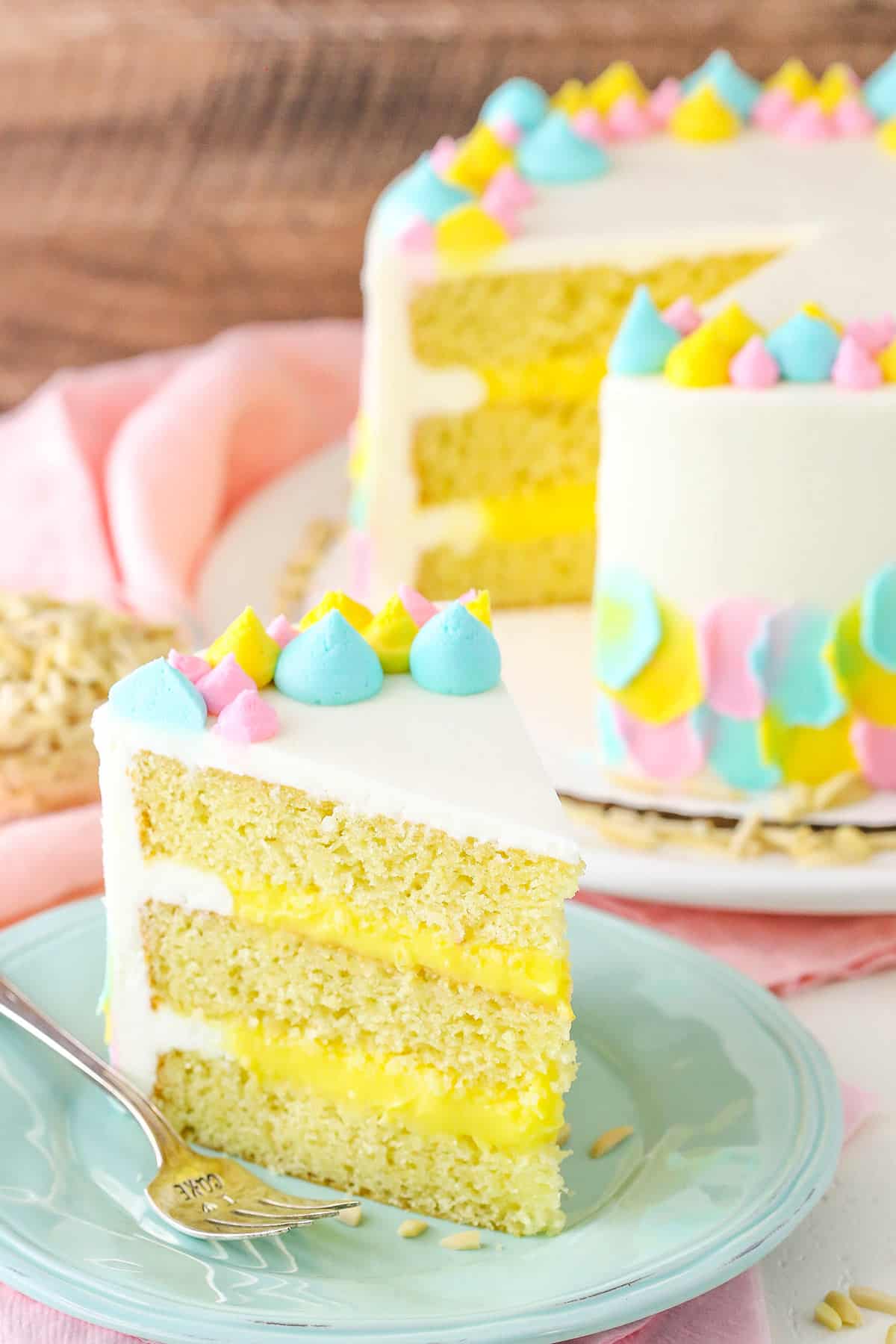 A slice of Almond Custard Layer Cake next to a fork on a light blue plate