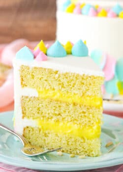 A slice of Almond Custard Layer Cake next to a fork on a light blue plate