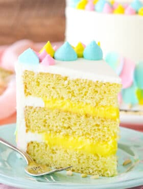 A slice of Almond Custard Layer Cake next to a fork on a light blue plate