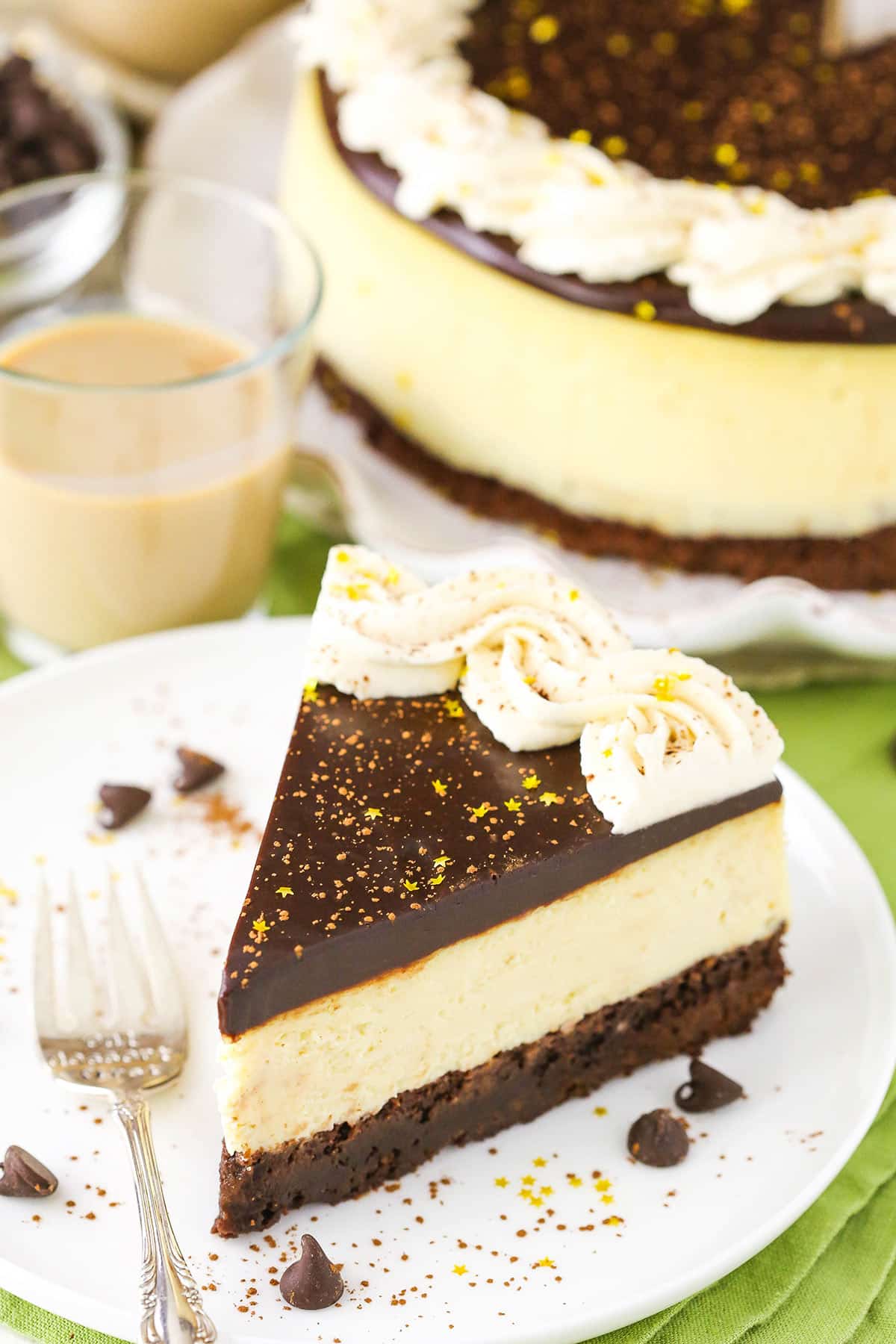 A slice of Baileys Brownie Cheesecake next to a fork on a white plate