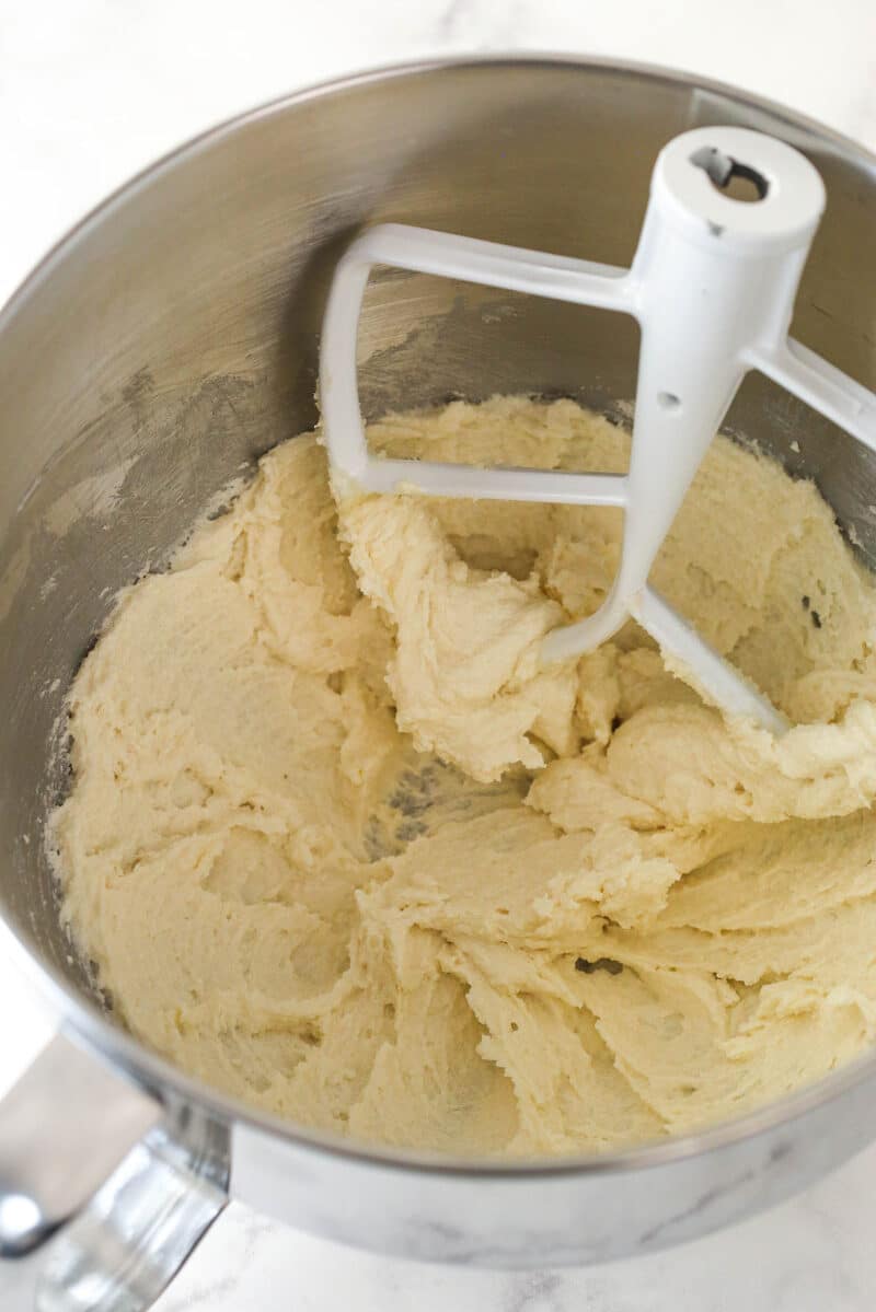 Creamed butter, sugar and vanilla in a metal mixing bowl.