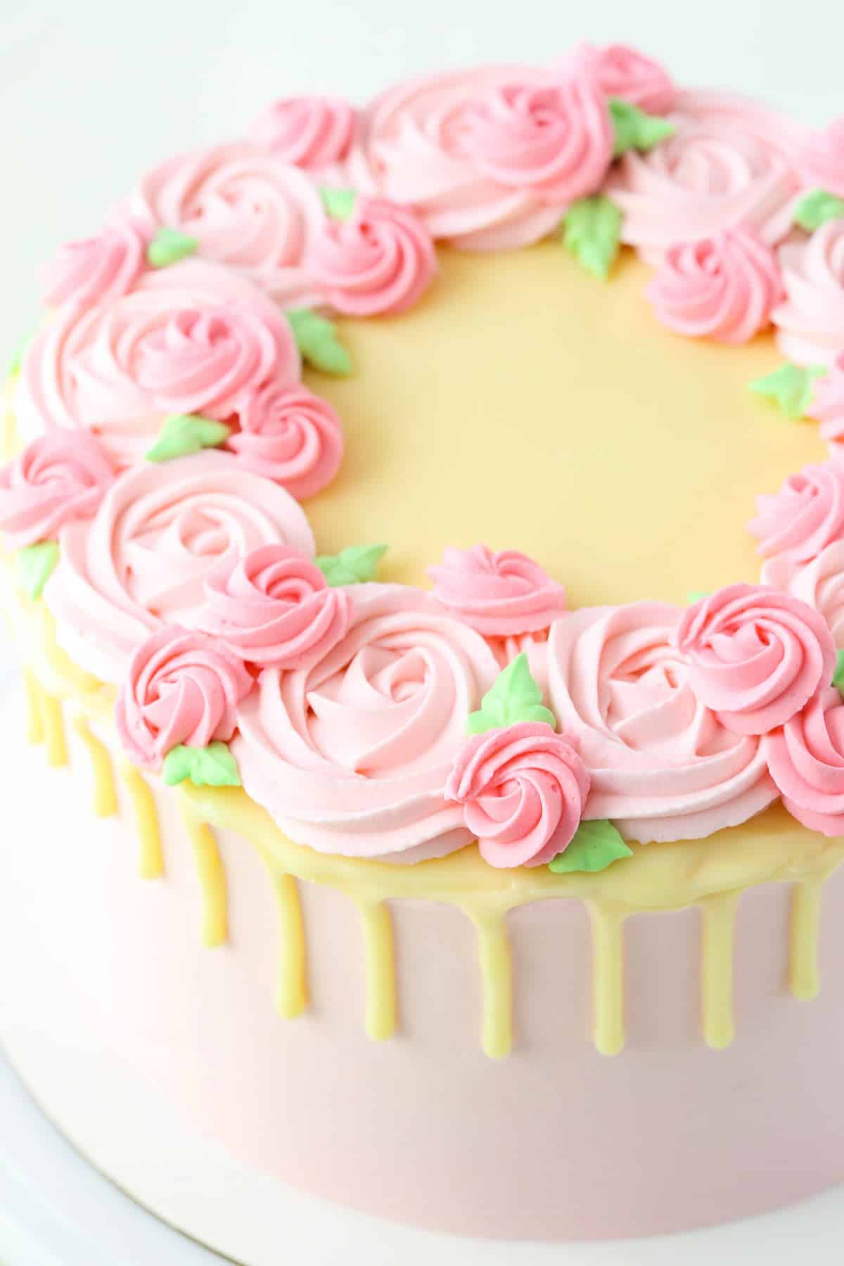 A full Carvel Cake with pink swirls on a white cake stand