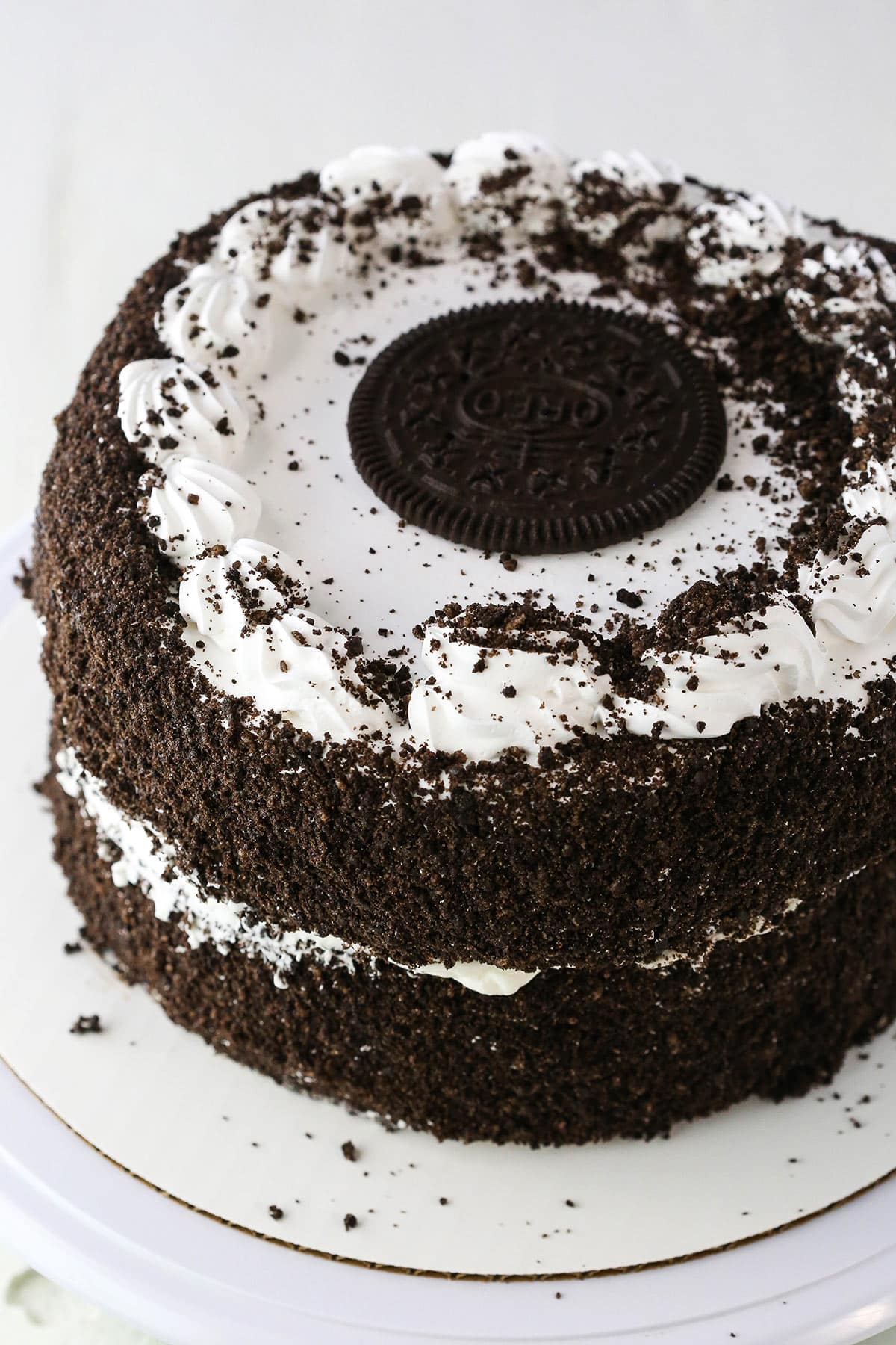 Two Oreo Ice Cream Cakes stacked on top of each other on a white cake stand