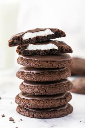 A stack of chocolate marshmallow cookies, with one cut in top on half to show the marshmallow inside