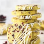 A stack of cranberry orange shortbread cookies, one leaning against the stack