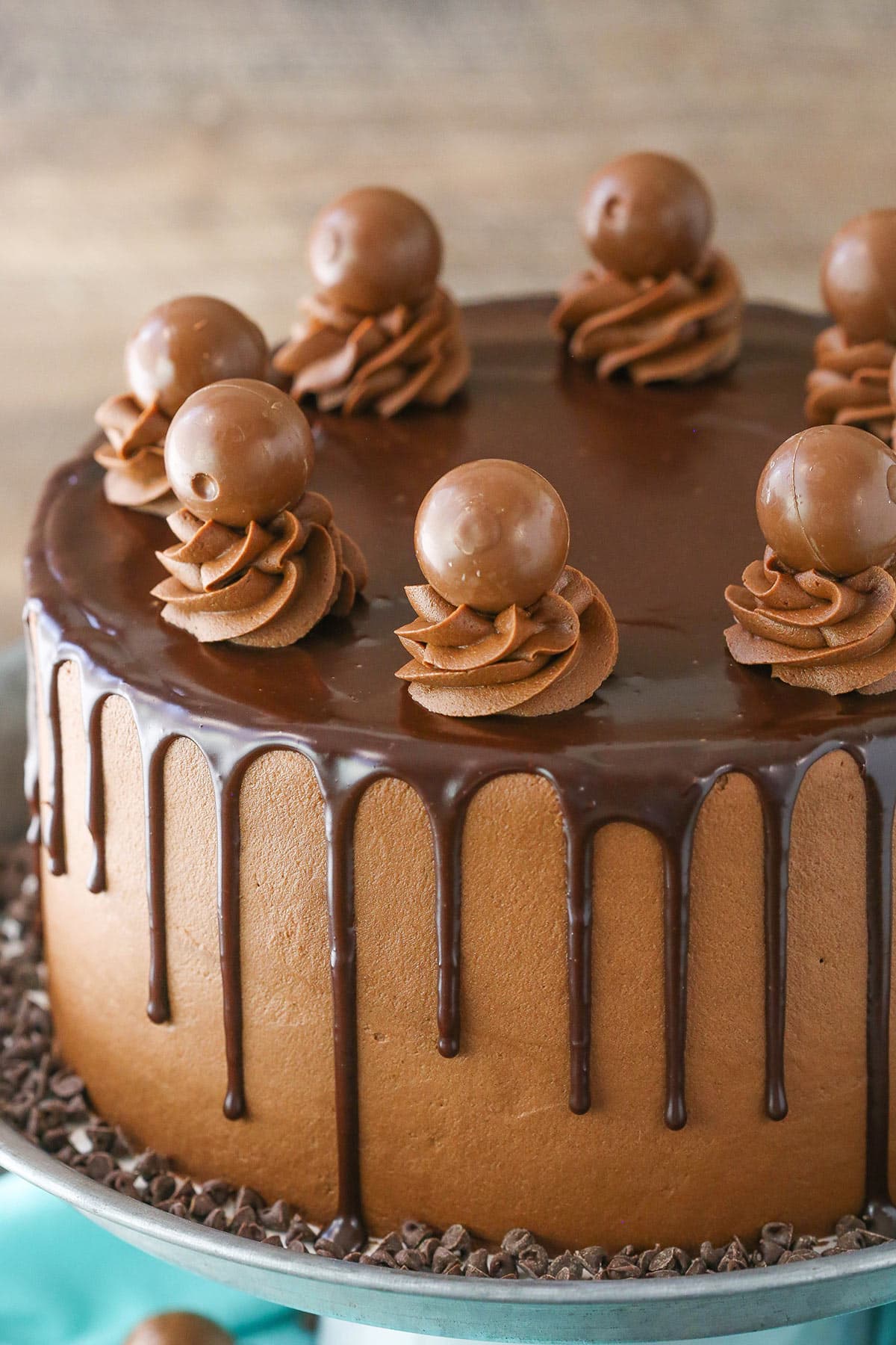 Side view of a full Drunken Chocolate Truffle Cake on a gray cake stand