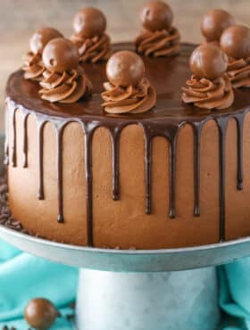 Side view of a full Drunken Chocolate Truffle Cake on a gray cake stand