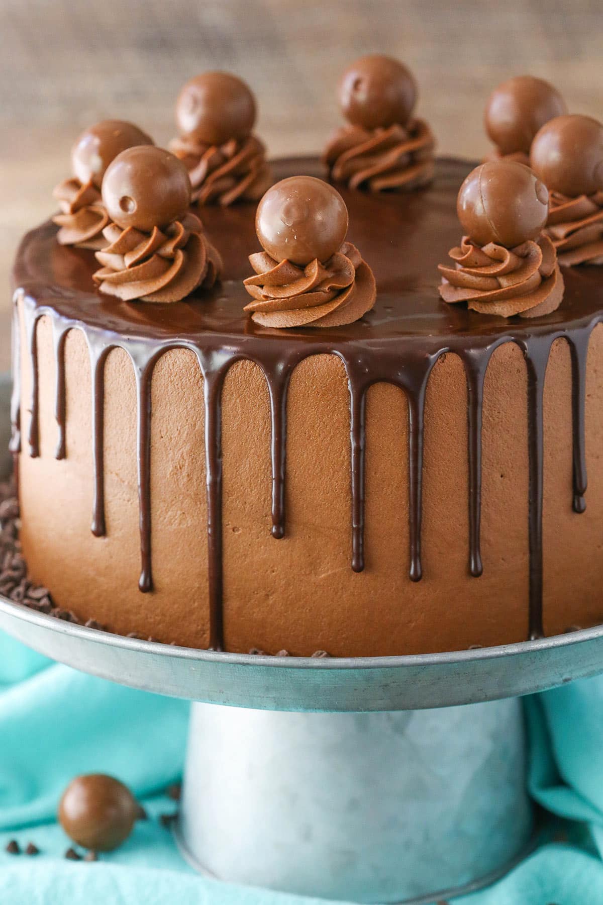 Side view of a full Drunken Chocolate Truffle Cake on a gray cake stand