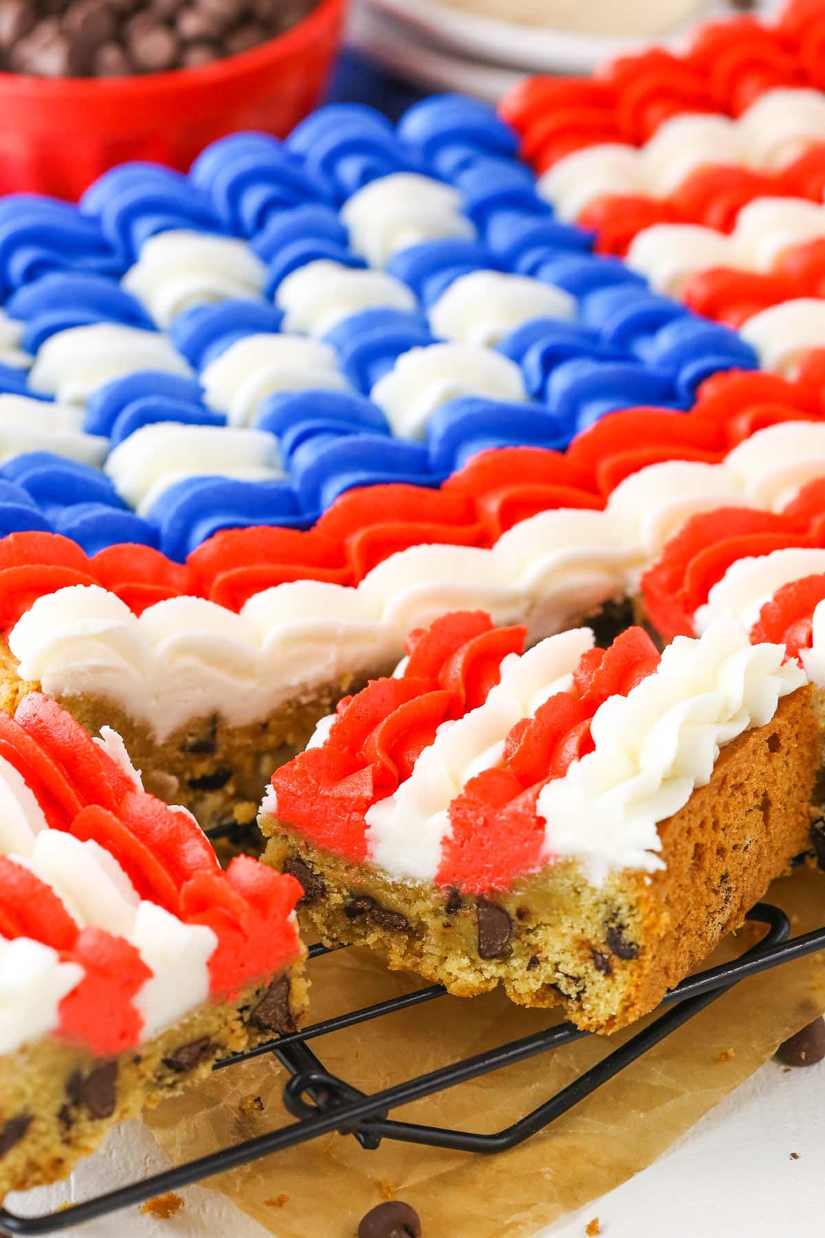 A slice of Flag Chocolate Chip Cookie Cake on a cooling rack