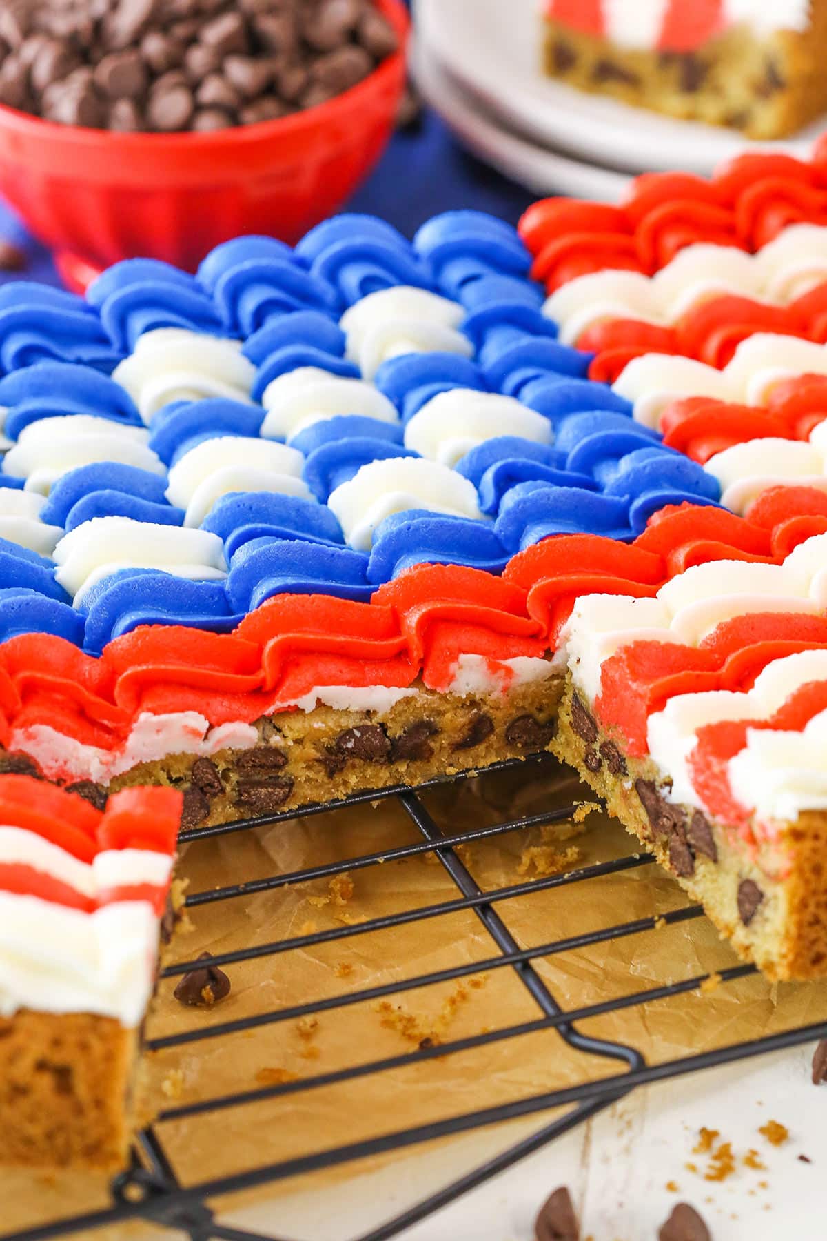 A Flag Chocolate Chip Cookie Cake with a slice removed on a cooling rack