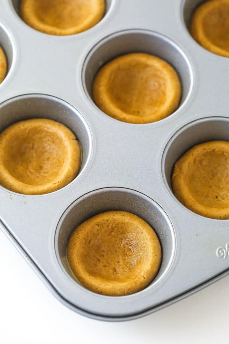 Gingerbread cookie dough pressed into baking cups.