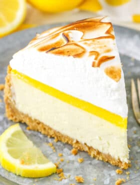 A slice of Lemon Meringue Cheesecake on a gray plate