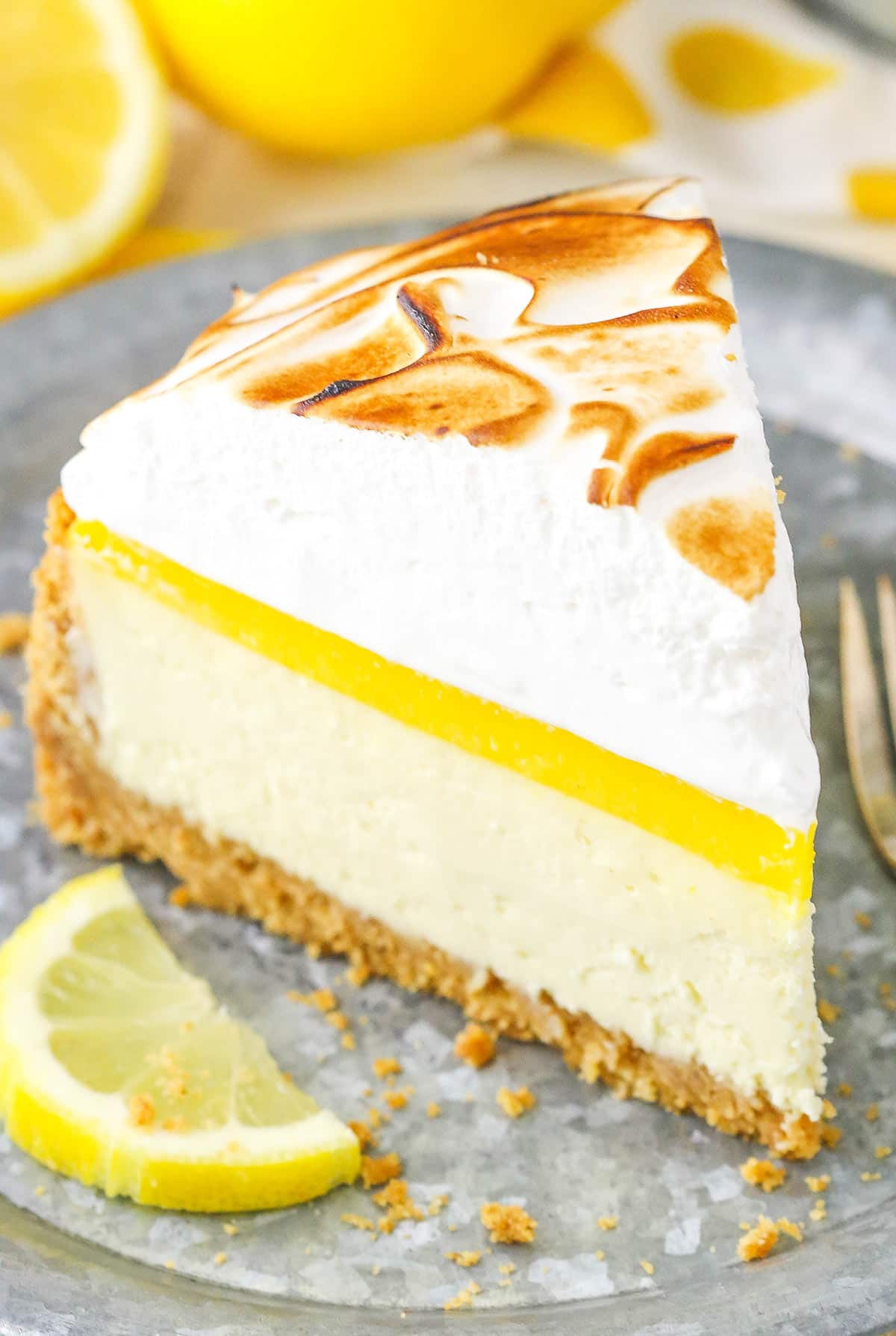 A slice of Lemon Meringue Cheesecake on a gray plate