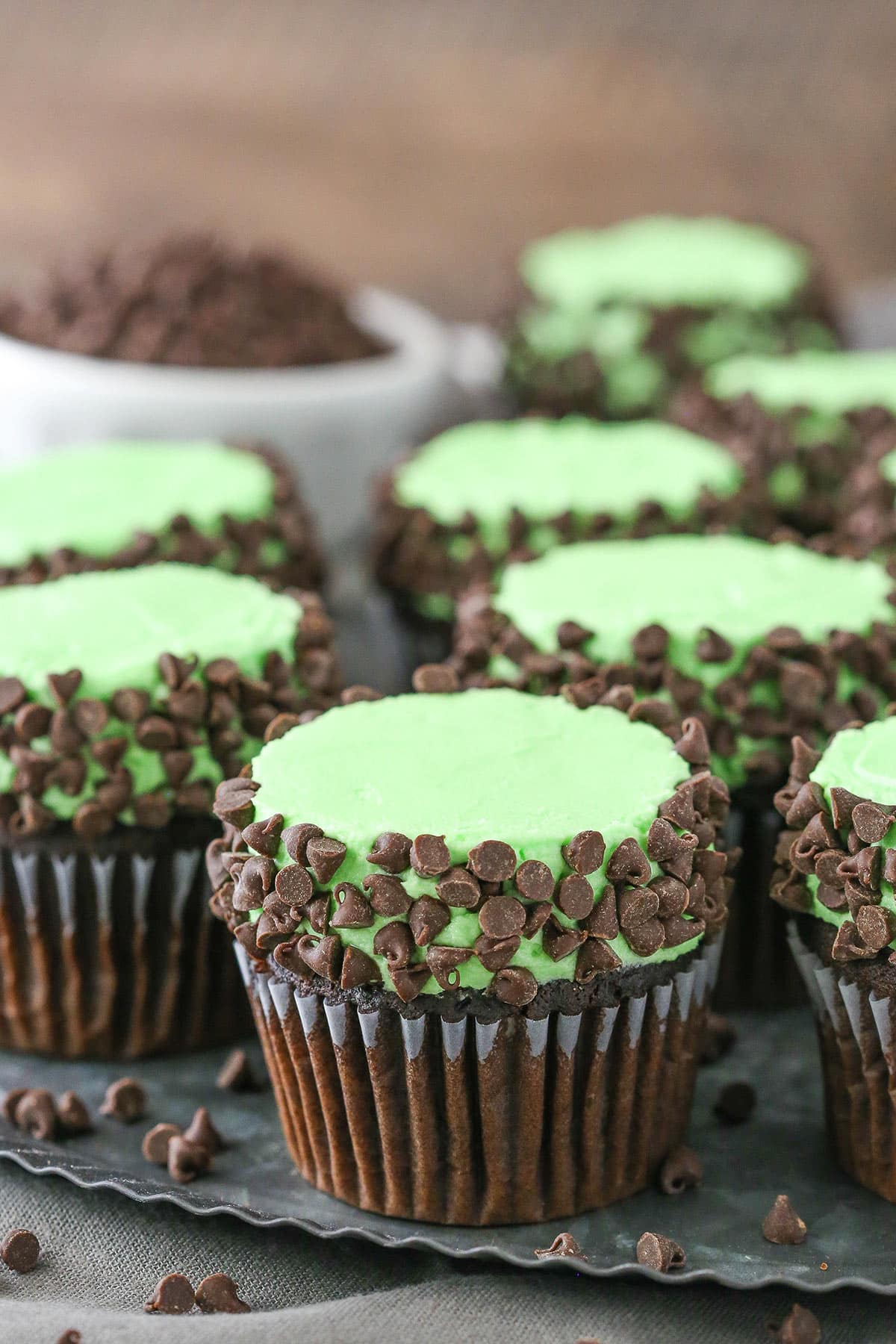 Side view of Mint Chocolate Chip Cupcakes on a gray plate