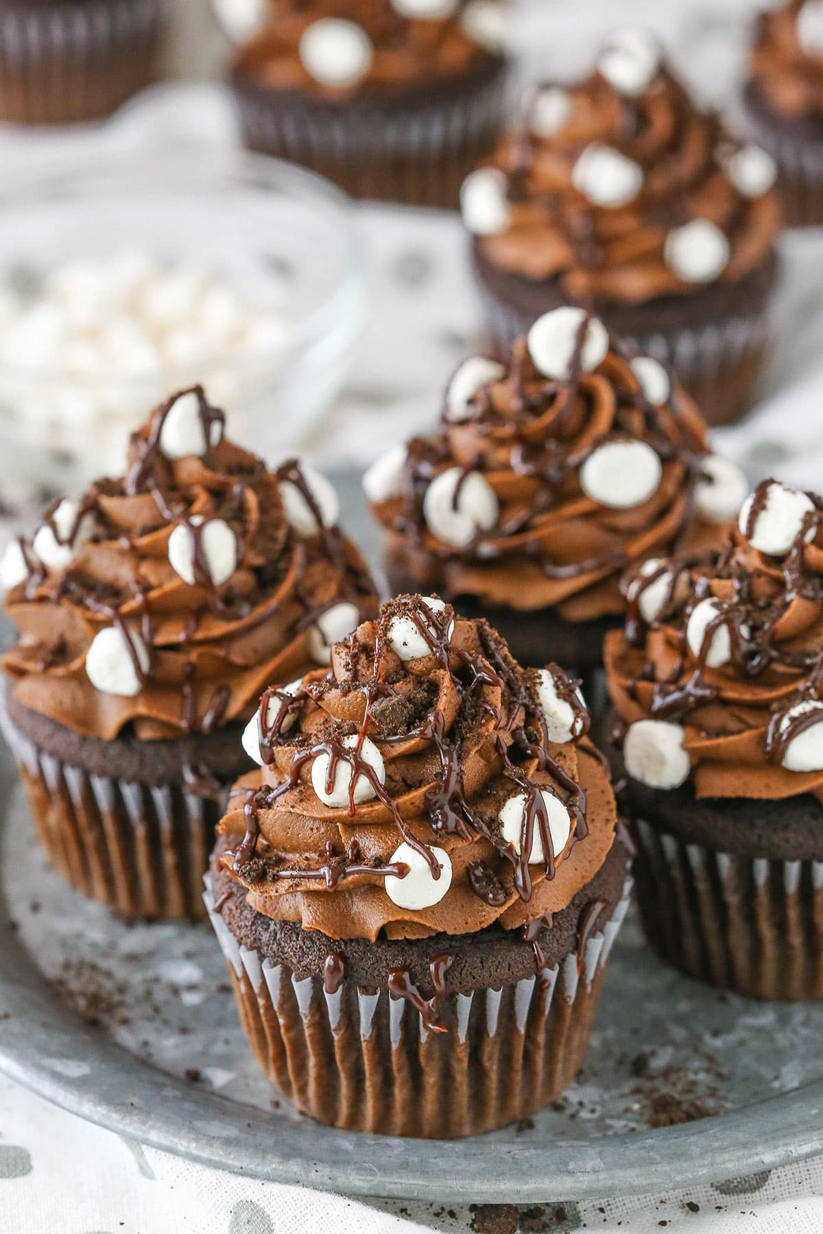 Four Mississippi Mud Cupcakes placed on a gray cake stand