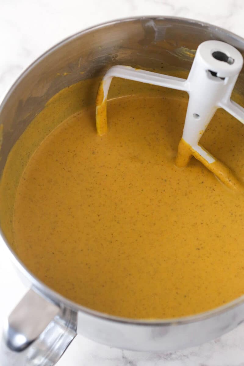 Pumpkin cheesecake filling in a silver mixing bowl.