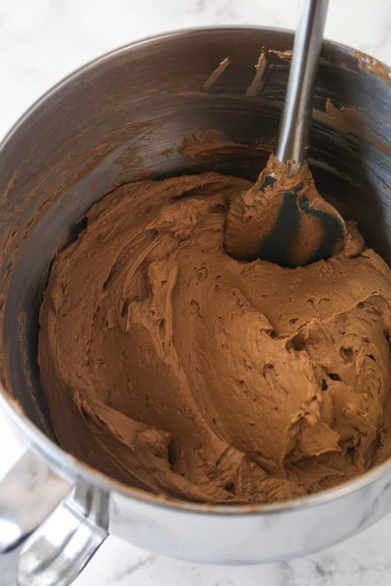 Chocolate frosting in a silver mixing bowl.