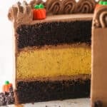 A Chocolate Pumpkin Cheesecake Cake with slices removed to show interior layers.