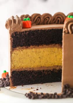 A Chocolate Pumpkin Cheesecake Cake with slices removed to show interior layers.