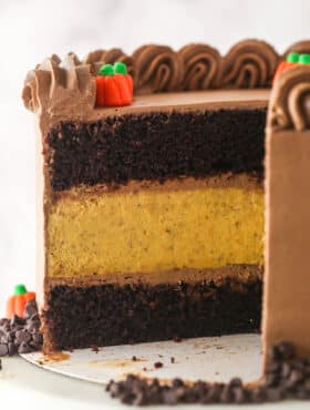 A Chocolate Pumpkin Cheesecake Cake with slices removed to show interior layers.