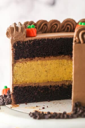 A Chocolate Pumpkin Cheesecake Cake with slices removed to show interior layers.