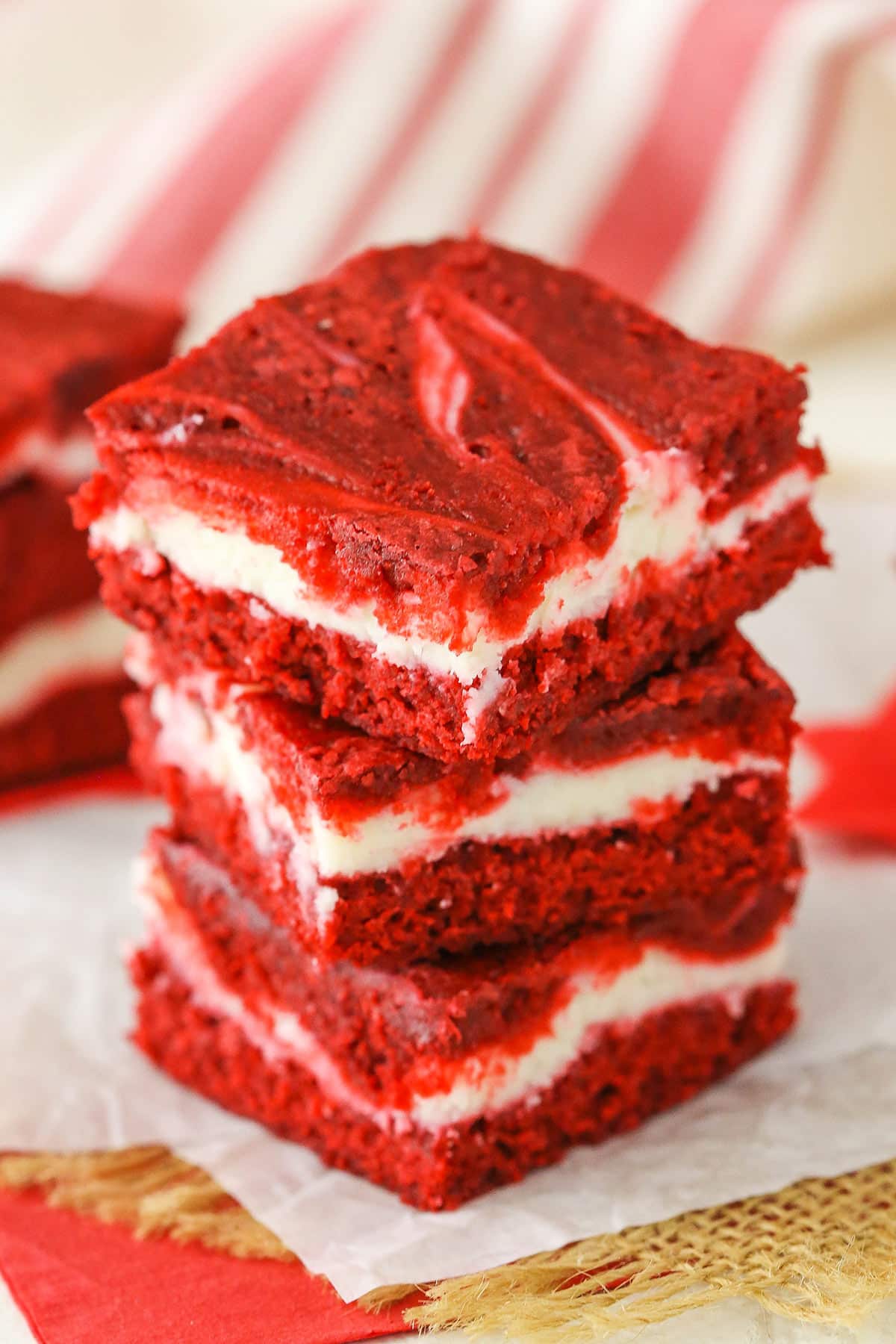 Three Red Velvet Cheesecake Swirl Brownies stacked on a white napkin